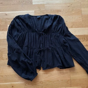 Svart blus med knyt och volanger - Svart blus från Gina tricot, stl S