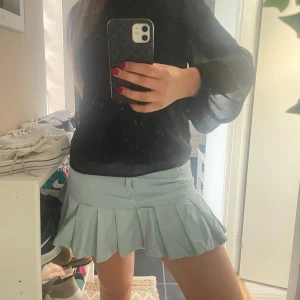 Ljusblå Volangkjol  - Superfin ljusblå kortkjol med plisserad nederdel och klassisk midja. Kjolen har en enkel design utan mönster och är perfekt för dig som gillar en sportig och söt stil. Passar perfekt till sneakers och en enkel topp.