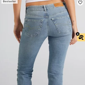 Ljusblå jeansbyxor från junkyard  - Snygga ljusblå jeansbyxor från junkyard med klassisk femficksdesign och coola kontrastsömmar på bakfickorna. Jeansen har normal passform och midja, tillverkade i mjukt denimtyg som sitter skönt hela dagen.