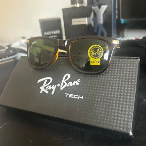 Ray-Ban Tech clubmaster - Snygga Ray-Ban Tech clubmaster solglasögon med klassisk brun och svart båge, guldiga detaljer och gröna G-15 linser. Ikonisk design som passar dig som vill ha en cool och tidlös look. Kommer med originalask.