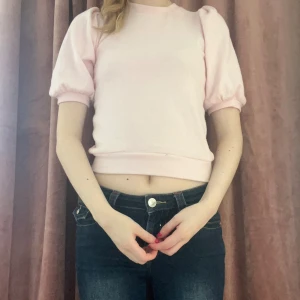 Ljusrosa croppad topp  - Supersöt ljusrosa croppad topp med puffiga kortärmar och rund halsringning. perfekt till jeans eller kjol. Enkel men trendig design som ger en gullig vibe.