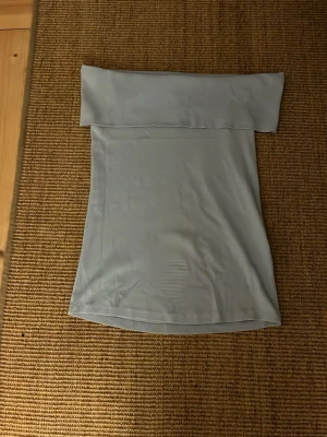 Ljusblå axelbandslös tubtopp - Säljer en ljusblå over shoulder topp har använt några gånger.