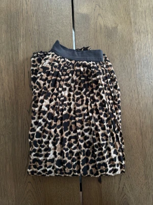 Leopardmönstrad plisserad kjol NA-KD - Leomönstrad plisserad kjol från NA-KD i storlek 34. Kjolen har elastisk midja och är i midi-längd. Knappt använd. 