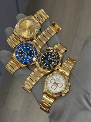 Klockor  - Bilden visar flera lyxiga armbandsur i guld, men ingen väst finns med. Vänligen ladda upp en bild på en väst för att få en beskrivning.