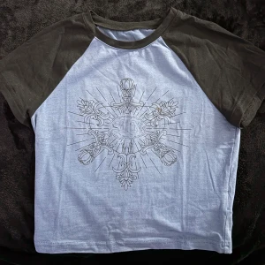 Blå och svart t-shirt  - Snygg t-shirt från shein i blått med svarta raglanärmar och coolt grafiskt tryck framtill. Skön passform och tillverkad i mjuk bomullsblandning. Perfekt för en chill och avslappnad stil.