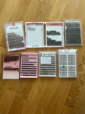 Mixade individuella lösögonfransar - Säljer flera förpackningar med individuella lösögonfransar i olika längder och tjocklekar. Fransarna är svarta och bruna kommer i kluster, perfekt för att bygga volym och längd. Förpackningarna är av plast med rosa, vit eller transparent bakgrund. Passar dig som gillar att fixa fransarna hemma.