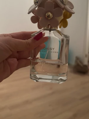 Daisy Eau So Fresh parfym - En stilren parfym från Marc Jacobs med lekfull blomdesign på korken. Daisy Eau So Fresh är perfekt för dig som vill ha en ikonisk flaska som sticker ut i samlingen. Volym och ingredienser syns ej på bilderna.