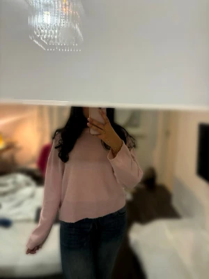 Ljusrosa stickad tröja - Mysig ljusrosa stickad tröja med rund hals och långa ärmar. Tröjan har en loose passform och är perfekt att bära till jeans eller kjol. Materialet känns mjukt och bekvämt mot huden, och färgen ger en fräsch vibe till din outfit.