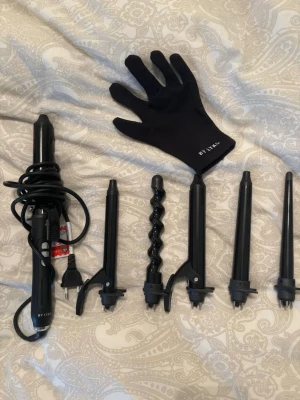 Lyko locktång multi med 6 delar - Lyko locktång multi med 6 utbytbara svarta värmeverktyg för olika lockar och vågor. Setet innehåller flera cylindrar i olika former och storlekar samt en vär enförhandske, perfekt sopport för styling. Allt är i svart och tillverkat i metall och värmetålig plast.