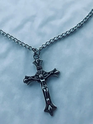 By prisförslag- silverfärgad korshalsband 45 cm - Kedja i silverfärg med ett detaljerat korshänge som har Jesusmotiv. Klassisk design med robust länk och cool vibe, perfekt för dig som vill addera en statement-accessoar till din stil.