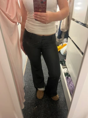 Lågmidjade kostymbyxor med fickor - Säljer ett par svarta bootcut byxor med låg midja och snygga fickor bak. Byxorna har en rak/ utsvängd passfrom! De är grå/svarta🖤