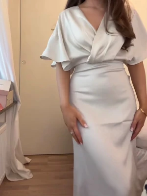 Satin wrap balklänning - Första bilden är inte min egna! Ljusblå ny balklänning i satin som sitter så bra!. Storlek 38. Nypris: 1449kr