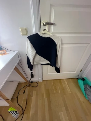 Svartvit stickad tröja - Säljer en snygg stickad tröja i svart och vitt med coolt diagonalt mönster. Tröjan har rund halsringning och långa ärmar. Perfekt för dig som gillar en enkel men ändå unik stil.