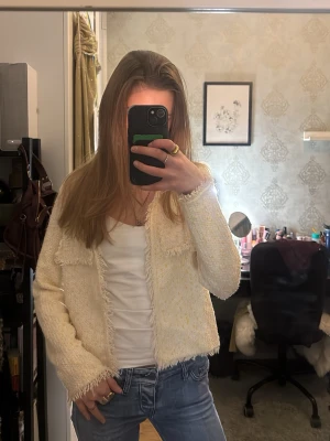 Beige kofta från Mango med fransar - Superfin beige kofta från Mango med diskreta gula detaljer. Koftan har fransade kanter, två fickor framtill 🥰