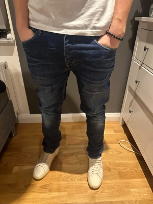 Mörkblå tiger of Sweden   - Säljer ett par mörkblå jeansbyxor från Pistolero i modellen Underground. Jeansen har klassisk femficksdesign, raka ben och snygga slitningar framtill. 