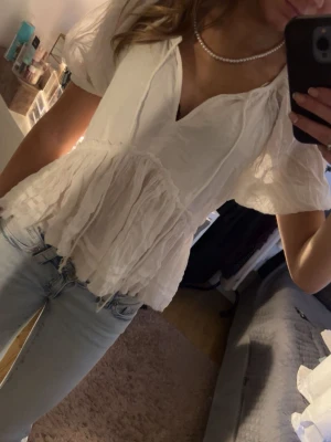 Snygg sommarblus med snören - En söt sommarblus som bara är andvänd fåtal gånger som passar perfekt till dig som gillar en söt och feminin look. Säljer pågrund av att den inte kommer till andvändning!