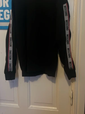 moschino tröja - skön stretchig tröja! remsan på armarna har släppt på några ställen men inget som påverkar funktion eller utseende. Skriv vid funderingar 
