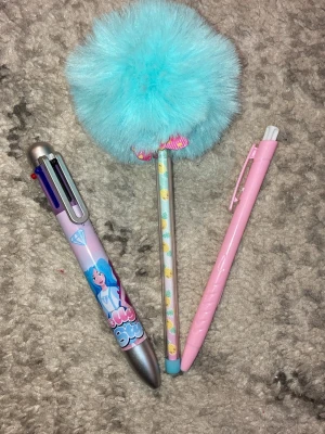 Ingen väst på bilderna - Bilderna visar tre olika pennor.En penna är rosa, en har ett blått fluffigt bol med ananasmönster, och en är en multifärgspenna med Dolly style design.