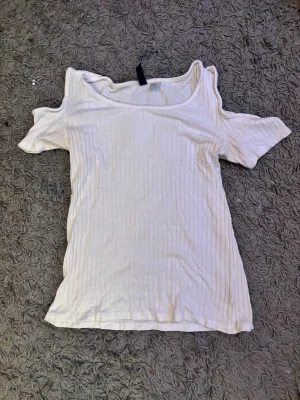 Topp med öppna axlar  - Jätte fin vit topp med öppna axlar, skick är svårt att sätta exakt då alla har olika åsikter men enligt mig är skicket bra och jag kan inte hitta några skador när jag kollar igenom
