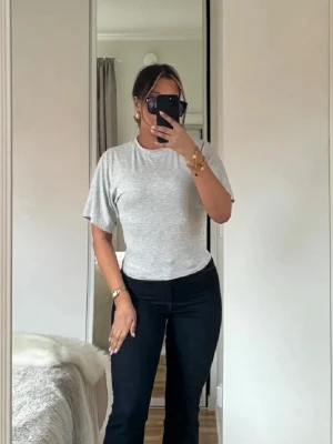Ljusgrå T-shirt med passform - Enkel och stilren ljusgrå t-shirt med rund hals och korta ärmar. Modellen är rak och något figurnära, perfekt till jeans eller kjol. T-shirten är gjord i mjuk bomull som känns skön mot huden. Detta är en tröja med figursydd midja och breda armar för en illusion av smal midja!!🫶🏽🤎 storlek xs men passar s