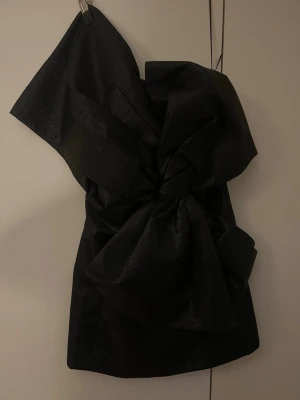 Svart one shoulder klänning med stor rosett - Från H&M, använd en gång, storlek 36