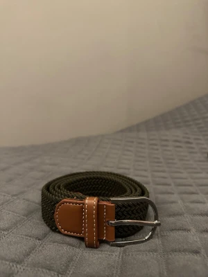 Grönt flätat bälte - Tja det är helt nytt från Bältgallerian. Det är 105cm långt och 3,5vm brett. Det är i ett elastiskt material så passar större storlekar. Vid köpa av flera minskad priset.