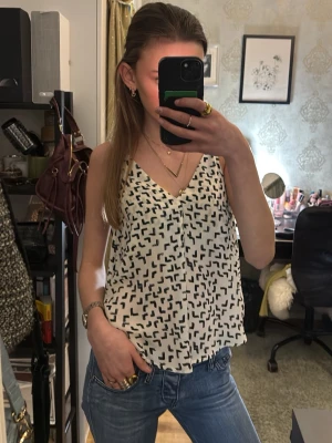 Vit och svart mönstrad linnetopp - Säljer en luftig vit linnetopp med svarta abstrakta mönster.🥰