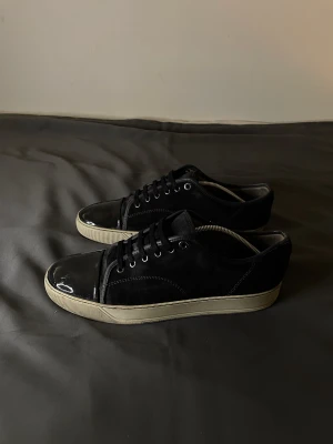 Svarta Lanvins sneakers  - Stillrena Lanvins med mörk Mocha och ljus sula, glansig framsida, tyvärr medföljer ingen box eller kvitto, storlek uk 10 vilket motsvarar 43-44 använda ett par gånger men fortfarande i bra skick! :)