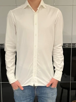 Vit skjorta Stenströms  - Snygg vit skjorta med klassisk krage och långa ärmar. Skjortan har en slim passform och stängs med knappar framtill. Perfekt för dig som gillar stilrena och enkla plagg. Materialet känns lätt och bekvämt mot huden.