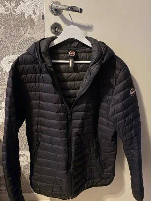 Svart pufferjacka från Colmar - Säljer en svart pufferjacka från Colmar med huva, använd en vinter finns inga defekter, bara att höra av sig vid vidare intresse så svarar jag så snabbt som möjligt! Ny pris ca 3500kr