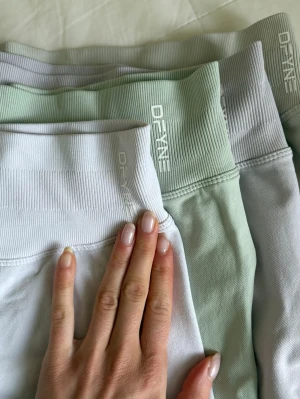 DFYNE IMPACT SHORTS 4.5”  - Säljer flera par seamless träningsshorts från DFYNE i ljusa pastellfärger som vitt, ljusgrått och ljusgrönt. De har ribbad hög midja och är tillverkade i stretchigt syntetmaterial som sitter tight och formar kroppen. Perfekta för gymmet eller annan träning. OBS DENNA ANNONS ÄR BARA FÖR 1 PAR! Säljer för jag använder XS nu mera 