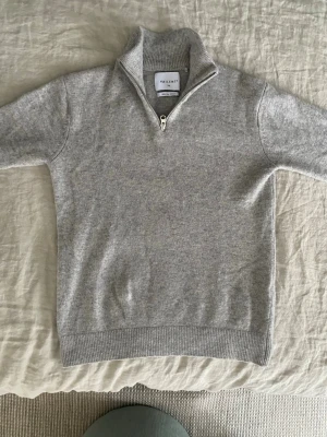 Grå halvzip stickad tröja Vaillent - Säljer en grå stickad tröja från Vailent med halvzip och hög krage. Tröjan är i mjuk merinoull och har ribbade muddar vid ärmslut och nederkant. Perfekt för lager på lager under höst och vinter. Tröjan har ett riktigt bra sick har knappt använt den. Ny pris är 800kr jag säljer den för 500kr eftersom den är knappt använd. Hör av dig vid minsta frågan