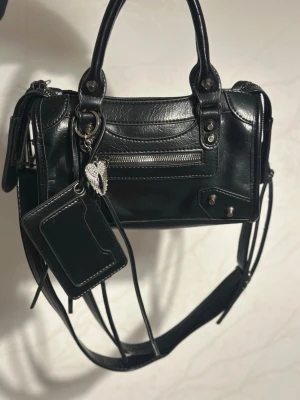 Balensiaga liknande väska  - Säljer min vintage Balensiaga liknande väska då den inte kommer till användning. Hängsmycket ingår. 