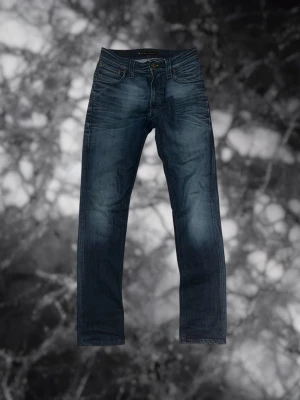 Nudie Jeans - Säljer ett par blåa Nudie Jeans i storlek W28/L32, mycket bra skick