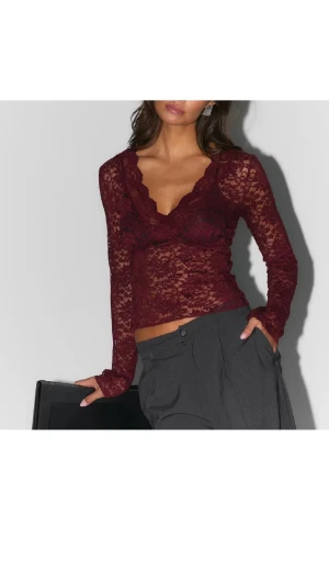 Vinröd spets topp från Gina Tricot - Säljer en vinröd långärmad spets topp från Gina Tricot. Toppen har v-ringning och är genombruten med blommigt spetsmönster. Han endast haft på mig den en gång. 