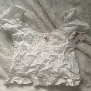 Vit blus med puffärm från Nelly - Söt Nelly top med lappen kvar! Säljer då jag aldrig använt den💗Storlek 36/S