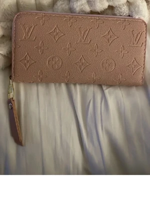 Rosa plånbok - Passa på! Rosa stor plånbok ca 20cm. Rymlig! Har fabriksfel (bruna sträck) mellan facken. Inget som stör funktionen alls. ❣️ 100:- IDAG! (Ej org såklart) gåva vid varje köp!