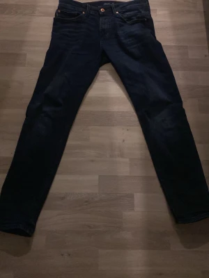 Mörkblå jeans från Bison Superflex - Säljer ett par mörkblå jeans från Bison Superflex. Snygga kopparfärgade knappar. Jeansen har en slim passform och är tillverkade i stretchigt jeansmaterial för extra komfort. Jätte bra kvalité och färgen håller sig kvar också. Perfekta för dig som gillar stilrena och bekväma jeans. Var inte för rädda för hur dom sitter för efter ett litet tag sitter dom perfekt på bena och i midjan "Tveka inte på att kontakta mig”