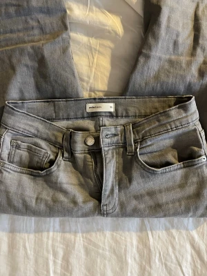 Grå bootcut jeans från Gina Tricot - Säljer ett par gråa bootcut jeans från Gina Tricot i storlek 36. Materialet är mjukt denim och färgen är ljusgrå, vilket är fräscht och snyggt. Säljer pgr av garderobsrensning. 