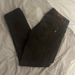 Dondup George - Riktigt snygga jeans från Dondup i modellen George. Jeansen är i storlek 32 men sitter lite kortare eftersom de har sytts upp ett fåtal centimeter. För övrigt är jeansen flitigt använda och i gott skick. Den ända defekten är ett litet hål i insidan av högra fickan som inte syns och inte påverkar fickans använding.