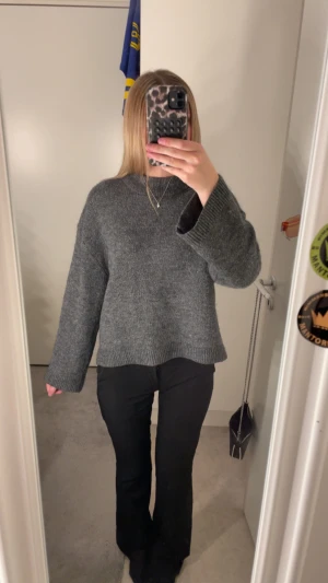 Mörkgrå stickad tröja - Säljer en väldigt fin mörkgrå stickad tröja med loose passform och långa ärmar. Tröjan har en enkel design med ribbade muddar vid ärmslut och nederkant.