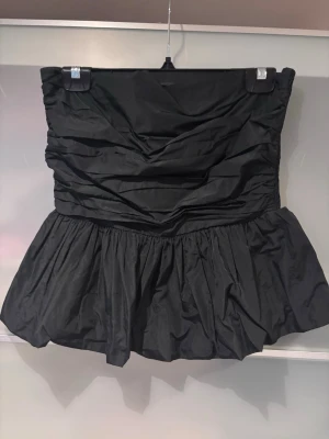 Svart bandeau tubtopp från ARKET - Supersnygg svart bandeau tubtopp från ARKET i storlek 40. Den är stretchig så passar både stora och mindre bröst! Inköpt för ca 800kr på Arket!