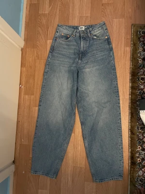 Blå wide jeans från 157 - Säljer ett par blå jeans från 157 med klassisk femficksdesign och hög midja. Modellen är loose och wide med raka ben, perfekt för en chill och avslappnad stil. Jeansen är tillverkade i robust denim och har en snygg ljus tvätt.