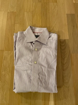 Randig skjorta från Eton, lila/vit - Säljer en snygg och klassisk skjorta från Eton i contemporary fit. Nypris ca 1700kr mitt pris endast 199 kr. Fraktar inom 1 dag, om du har någon fundering så är det bara att höra av sig😊