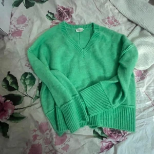Grön stickad v-ringad tröja - Snygg grön stickad tröja från C&A med v-ringad hals och breda ribbade muddar vid ärmslut och nederkant. Perfekt för dig som gillar färg och vill ha en mysig och stilren look. Passar dig som vill ha en chill och trendig vibe.
