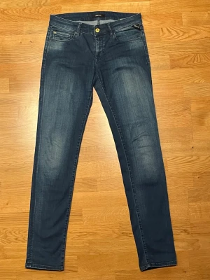 Replay jeans  W31 L34 - Snygga blå jeans från Replay i modellen slim fit. Klassisk femficksdesign, guldfärgad knapp och diskreta slitningar framtill. Jeansen har raka ben och är tillverkade i mjukt denimtyg som sitter skönt hela dagen.