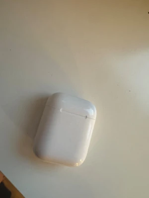 Apple AirPods 2 - Säljer ett par Apple AirPods 2 med laddningsetui. Fungerar utmärkt, trådlös anslutning och snabb laddning. Viss kosmetisk smuts och mindre repor syns på etuiet, men hörlurarna är i gott skick. Kommer med paketet dock utan laddare!