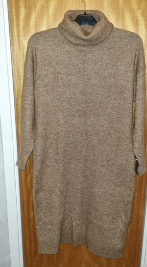 Beige stickad poloklänning - Mysig beige stickad klänning med polokrage och trekvartsärm. Perfekt för kyligare dagar och enkel att styla med boots eller sneakers. Rak passform och mjukt material som känns skönt mot huden. Storlek xs men kan passa som S 