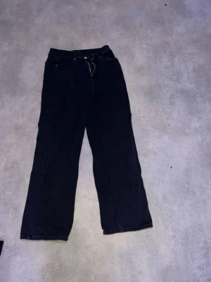 Mörkblå raka jeans - Snygga mörkblå jeans med rak passform och klassisk femficksdesign. Jeansen har normal midja och är tillverkade i ett robust denimtyg som ger en tidlös look. Perfekta för dig som gillar en enkel och stilren vibe.