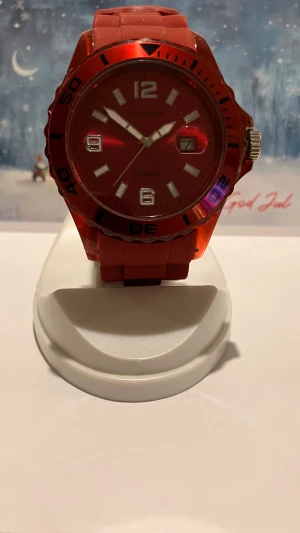 Röd /Vinröd  Sekonda klocka med silikonarmband - Cool röd/vineöd  klocka från Sekonda med matchande rött silikonarmband och stor boett. Urtavlan är röd med silvriga detaljer, datumvisning och tydliga siffror. Vattentät upp till 50 meter och har en robust känsla. Perfekt för dig som gillar sportig stil.